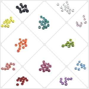 Puede incluir: Surtido de botones de dos agujeros en varios colores, incluyendo negro, amarillo, verde azulado, naranja, verde, rosa, rojo, azul claro, morado y blanco. Los botones están dispuestos en una cuadrícula sobre un fondo blanco.