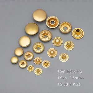Puede incluir: Un juego de botones a presión de metal dorado, que incluye una tapa, un casquillo, un remache y un poste. El juego incluye botones a presión de diferentes tamaños.