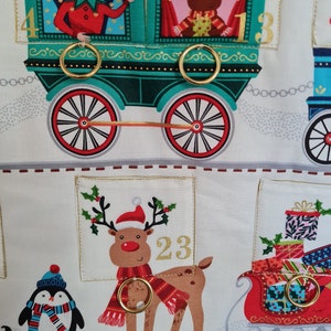 Adventskalender mit Taschen zum füllen und Ringe für kleine Päckchen. Der Kalender ist ein Motiv aus Eisenbahn mit Weihnachtsmann und Wichtel.
