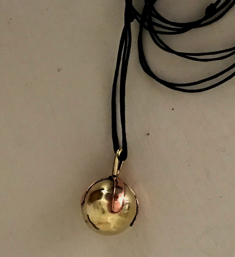 Brass Ball Pendant with a Copper X across the top on a Black Leather cord.