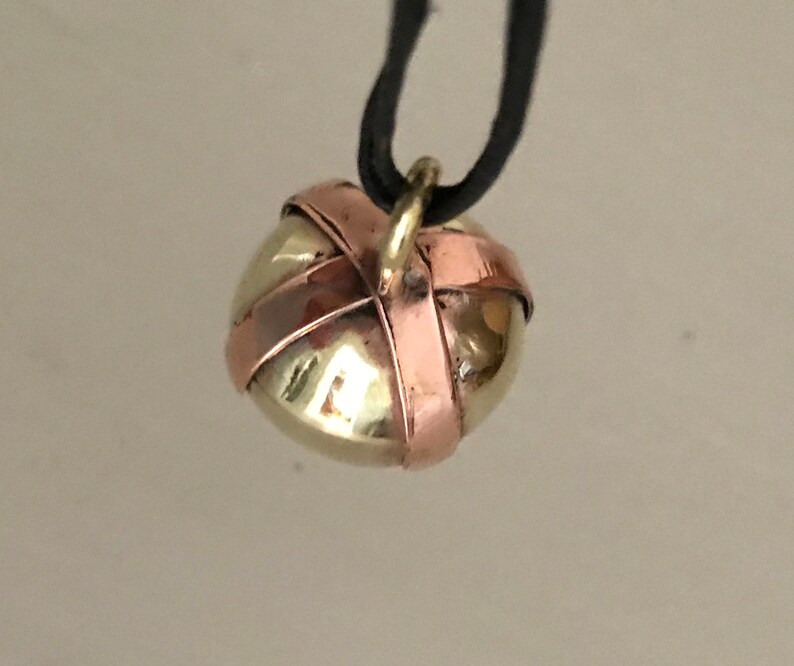 Brass Ball Pendant with a Copper X across the top on a Black Leather cord.