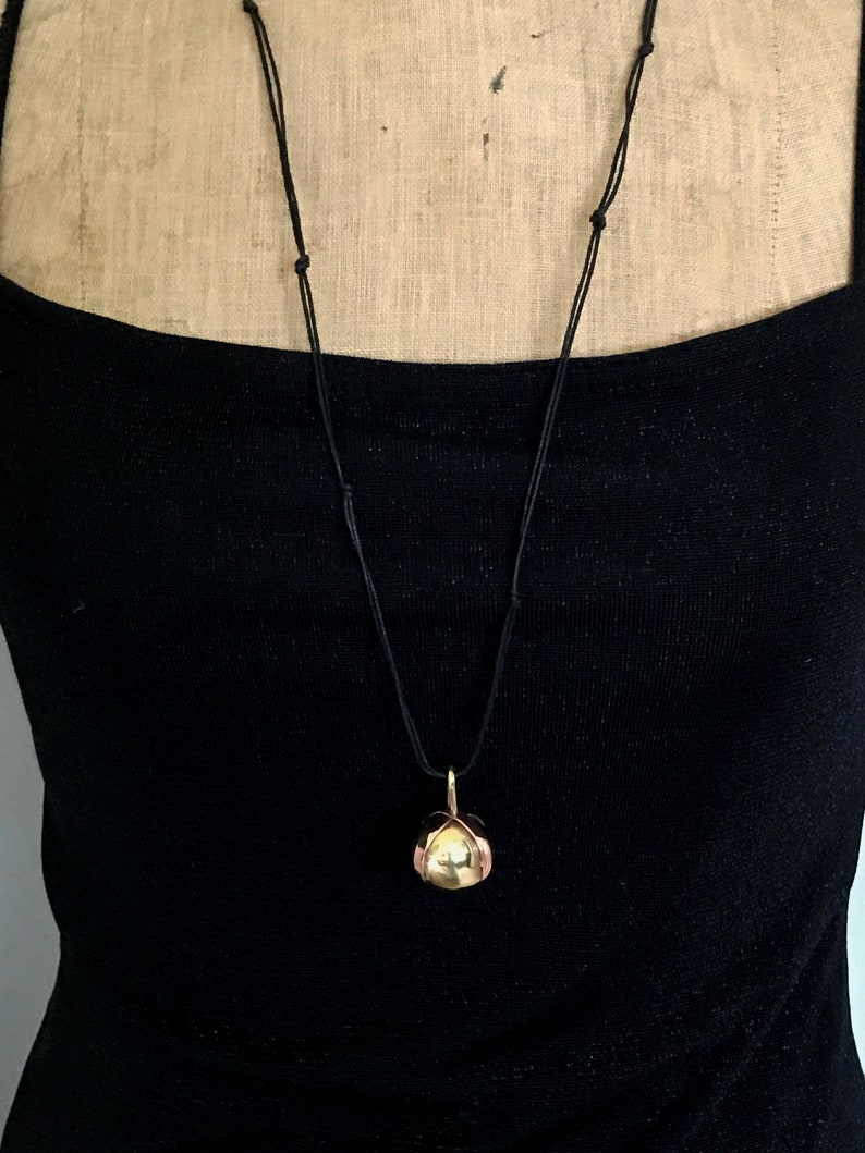 Brass Ball Pendant with a Copper X across the top on a Black Leather cord.