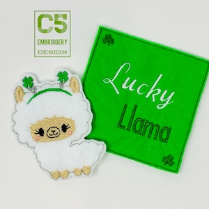 Könnte beinhalten: Ein weiß gestickter Lama mit grünen Kleeblatt-Kopfbedeckungen auf einem grünen Filz-Hintergrund mit dem Text "Lucky Llama" in weißer Stickerei.