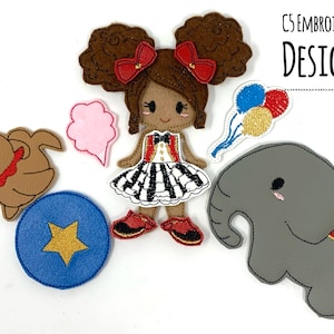 May include: A set of felt applique patches featuring a girl with brown hair and a red bow, a dog, an elephant, a cotton candy cloud, a blue ball with a yellow star, and a bunch of balloons. The patches are designed for embroidery and are perfect for creating a whimsical circus scene.