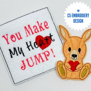 Puede incluir: Parche bordado con un canguro sosteniendo un corazón rojo y el texto "You Make My Heart Jump!" en letras rosas y negras.