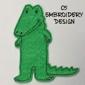 May include: Green felt applique of a smiling alligator with a black outline. The text "C5 EMBROIDERY DESIGN" is in the upper right corner of the image.