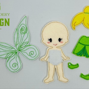 May include: Embroidered felt doll with a green dress, yellow hair, and butterfly wings. The doll is designed for a craft project.