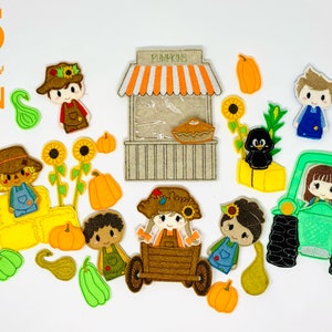 May include: A set of 11 felt applique designs featuring a fall harvest theme. The designs include a scarecrow, a pumpkin patch, a farmer in a wagon, a farmer at a pumpkin stand, a farmer driving a tractor, and a black crow.