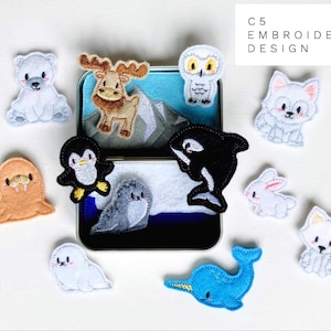 Puede incluir: Un conjunto de 10 parches de animales de fieltro bordados en una caja de hojalata. Los parches presentan una variedad de animales árticos, incluyendo un oso polar, un alce, un búho, un zorro, una morsa, un pingüino, una foca, un narval, un conejo y un narval. Los parches son perfectos para agregar un toque de fantasía a cualquier proyecto.