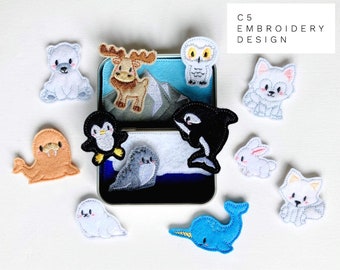 May include: A set of 10 embroidered felt animal patches in a tin box. The patches feature a variety of arctic animals, including a polar bear, a moose, an owl, a fox, a walrus, a penguin, a seal, a narwhal, a rabbit, and a narwhal. The patches are perfect for adding a touch of whimsy to any project.