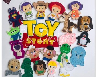 May include: A collection of felt character appliques featuring various figures from the Toy Story franchise, including a cowboy, space ranger, cowgirl, and dinosaur. The centre features a yellow and red fabric patch with the text TOY STORY.
