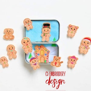 Könnte beinhalten: Gestickte Weihnachtsornamente aus Filz mit Lebkuchenmännchen, einem Haus und einem Hund. Die Ornamente umgeben eine offene Metallbox mit blauem Filzinnenraum. Der Text "C5 EMBROIDERY design" ist unten zu sehen.