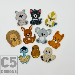 May include: A set of ten felt appliques featuring Australian animals. The appliques are colorful and feature a variety of animals, including a koala, a kangaroo, a platypus, a kookaburra, a echidna, a Tasmanian devil, a wombat, a dingo, a quokka, and a cassowary.