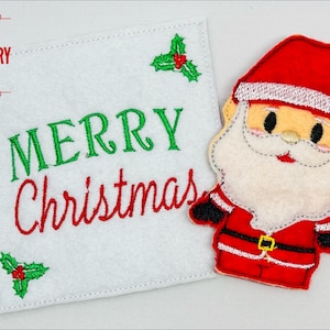 May include: A white felt card with the text "MERRY Christmas" embroidered in green and red. A red felt Santa Claus finger puppet is attached to the card.