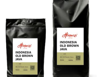 May include: Two black coffee bags with white labels. The labels read "Hormozi coffee INDONESIA OLD BROWN JAVA". The bags have a small, round, dark brown valve. The bottom of the label has the word "Washed".