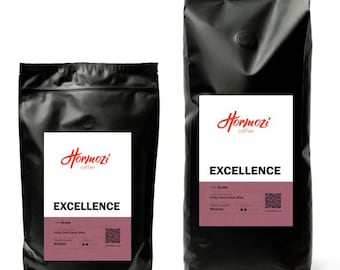May include: Two black coffee bags with white labels featuring the "Hormozi coffee" logo in red script. The labels read "EXCELLENCE" in bold letters. The smaller bag is on the left, and the larger bag is on the right.