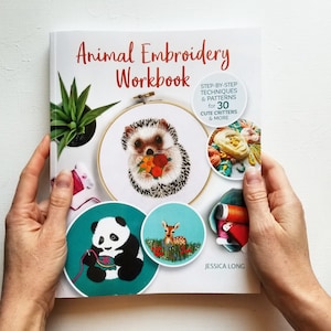 May include: A white book with the title "Animal Embroidery Workbook" and a colorful illustration of a hedgehog on the cover. The book includes step-by-step techniques and patterns for 30 cute critters and more.