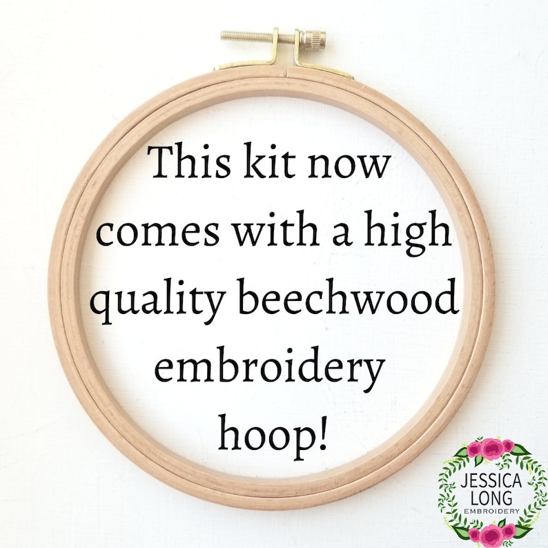 Puede incluir: Primer plano de un aro de bordado de madera con el texto "This kit now comes with a high quality beechwood embroidery hoop!" impreso en la tela dentro del aro.