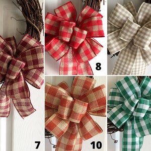 May include: A collection of six different plaid bows, each with a different color combination. The bows are made of a burlap-like material and are tied with a simple knot. The colors include red, tan, green, and burgundy.