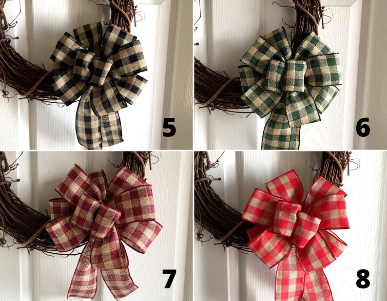 May include: A collection of four grapevine wreaths, each adorned with a large, plaid fabric bow. The bows vary in color, including black and tan, green and tan, burgundy and tan, and red and tan. The wreaths are displayed against a white door.