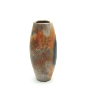 Pode incluir: Um vaso de cerâmica alto e oval com uma superfície texturizada. O vaso apresenta uma mistura de cores, incluindo cinza, laranja e preto. O design tem uma estética rústica e terrosa, adequada para decoração de interiores.