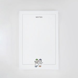 May include: White notepad with the word "NOTES" printed at the top. Two snowmen are skiing at the bottom of the notepad.