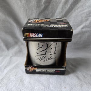 May include: A silver steel can holder with the number 24 and a signature on it. The holder is in a box with the words "Steel Can Holder" and "NASCAR" on it.