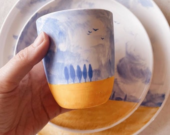 Ceramic porcelain tumbler with handpainted blue and yellow landscape. Coffee mug