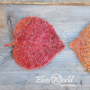 Puede incluir: Dos posavasos de punto en forma de hoja, uno rojo y otro naranja, sobre una superficie de madera. Los posavasos están hechos con un hilo texturizado y tienen un aspecto ligeramente peludo. El texto "Elves World Toys & Patterns" es visible en la parte inferior de la imagen.