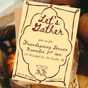 Può includere: Un invito color crema con testo bordeaux e un bordo decorativo. L'invito recita "Let's Gather" e invita gli ospiti a una cena del Ringraziamento il 24 novembre alle 18:00. Include indirizzo e informazioni RSVP.