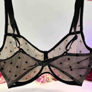 May include: Black polka dot mesh bra with adjustable straps and a bow detail in the centre.