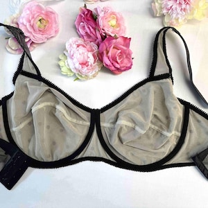 May include: A black and beige polka dot bra with adjustable straps and black trim.