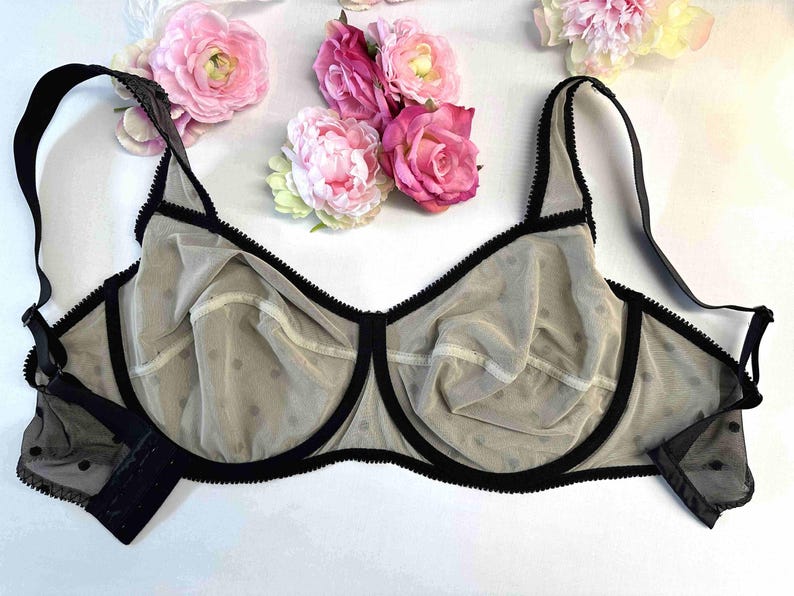May include: A black and beige polka dot bra with adjustable straps and black trim.