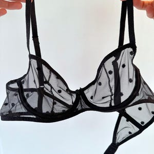 May include: Black polka dot mesh bra with adjustable straps and a delicate lace trim.