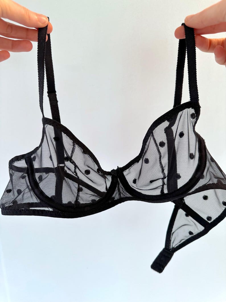 May include: Black polka dot mesh bra with adjustable straps and a delicate lace trim.