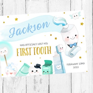 May include: A blue and white tooth-themed first tooth announcement card with the name Jackson and the date February 23rd, 2022. The card features a cartoon tooth with a bow tie and a tube of toothpaste.