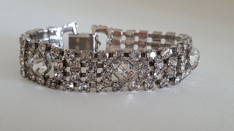 Peut inclure: Un bracelet argent&eacute; avec une rang&eacute;e de strass transparents. Le bracelet a une fermeture &agrave; fermoir.