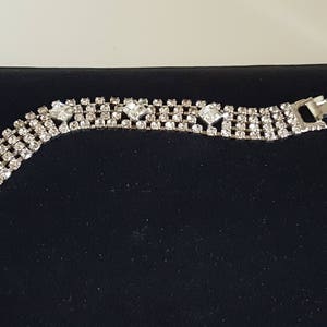 Peut inclure: Un bracelet en argent serti de strass avec une fermeture &agrave; fermoir. Le bracelet est compos&eacute; de plusieurs rang&eacute;es de petits strass.