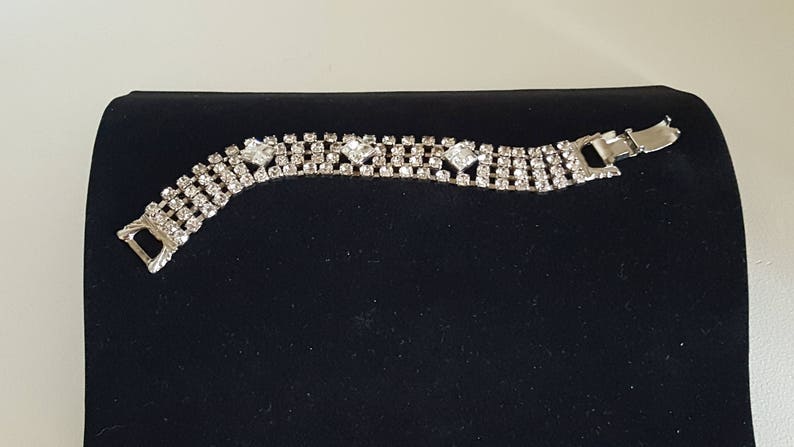 Peut inclure: Un bracelet en argent serti de strass avec une fermeture &agrave; fermoir. Le bracelet est compos&eacute; de plusieurs rang&eacute;es de petits strass.