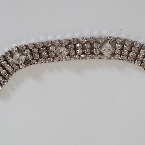 Peut inclure: Un bracelet argent&eacute; avec une rang&eacute;e de strass transparents. Le bracelet a une fermeture &agrave; fermoir.