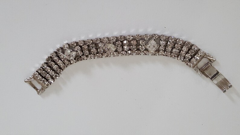 Peut inclure: Un bracelet argent&eacute; avec une rang&eacute;e de strass transparents. Le bracelet a une fermeture &agrave; fermoir.