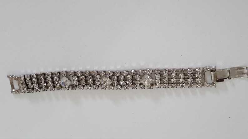 Peut inclure: Un bracelet argent&eacute; avec une rang&eacute;e de strass transparents et une fermeture &agrave; fermoir.