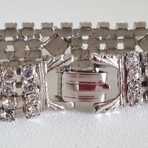 Peut inclure: Un bracelet argent&eacute; avec une rang&eacute;e de strass transparents. Le bracelet a une fermeture &agrave; fermoir.