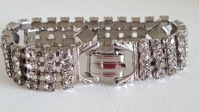 Peut inclure: Un bracelet argent&eacute; avec une rang&eacute;e de strass transparents. Le bracelet a une fermeture &agrave; fermoir.