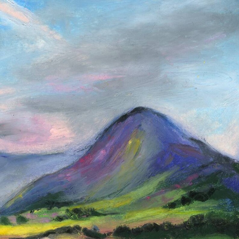 May include: An original pastel painting of a mountain landscape. The mountain is painted in shades of purple and blue, with green and yellow accents on the hillside. The sky is a mix of blue, gray, and pink hues, creating a soft, atmospheric effect.