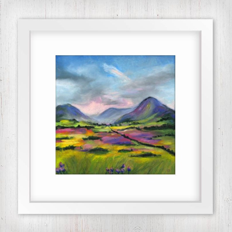 May include: A framed landscape painting depicts a vibrant field of purple, yellow, and green flowers beneath rolling green and purple mountains. The sky transitions from blue to gray, with a hint of pink.