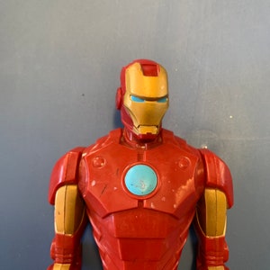 K&ouml;nnte beinhalten: Rote und goldene Plastik-Actionfigur von Iron Man. Die Figur hat eine blaue und silberne Gesichtsmaske mit einer roten Brustplatte.