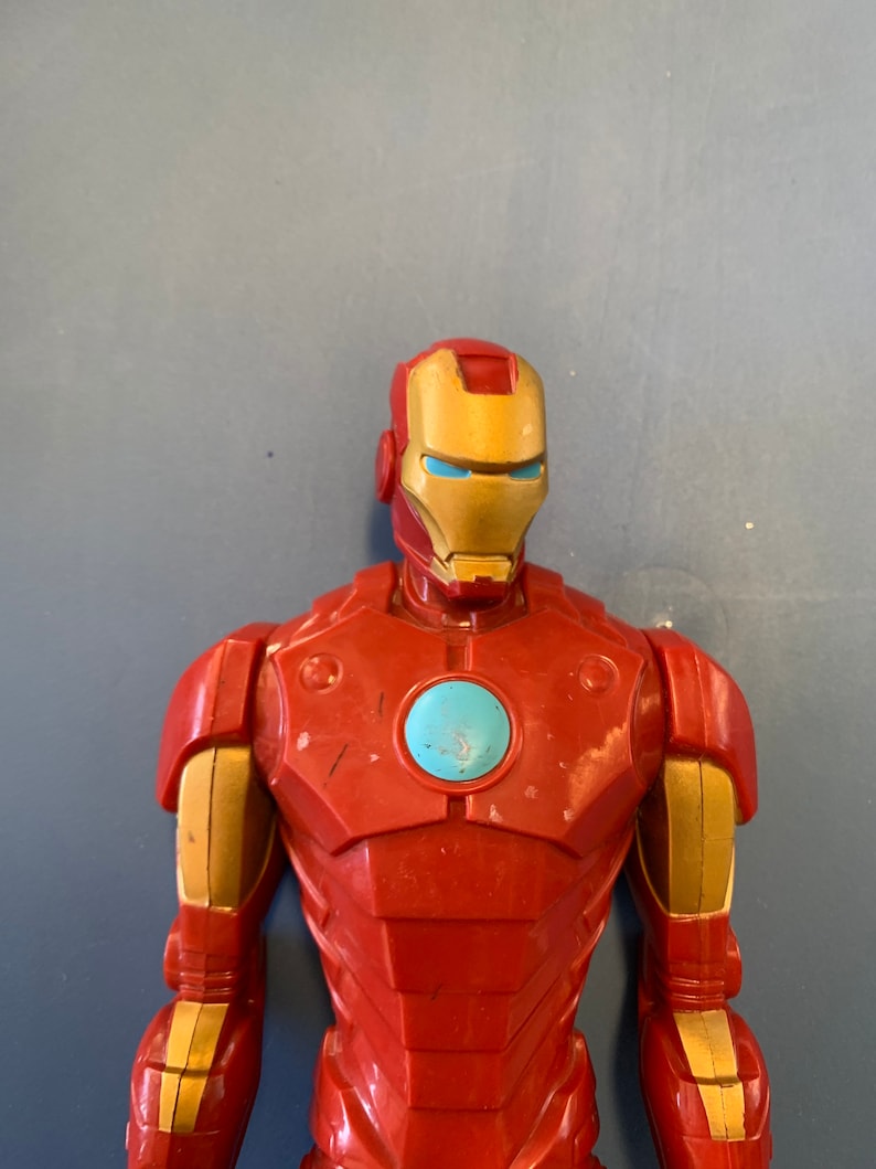 K&ouml;nnte beinhalten: Rote und goldene Plastik-Actionfigur von Iron Man. Die Figur hat eine blaue und silberne Gesichtsmaske mit einer roten Brustplatte.