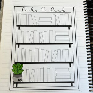 May include: A black and white printable bookshelf with the text "Books To Read" at the top. The bookshelf has four shelves with blank spaces for writing in the titles of books. A small potted plant with green leaves is on the bottom shelf.