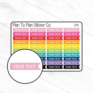 May include: A sheet of colorful planner stickers from Plan To Plan Sticker Co. Each sticker is a banner shape with the text "YOUR TEXT" in a variety of colors, including pink, red, orange, yellow, green, blue, purple, and black. A circular close-up shows a pink banner.